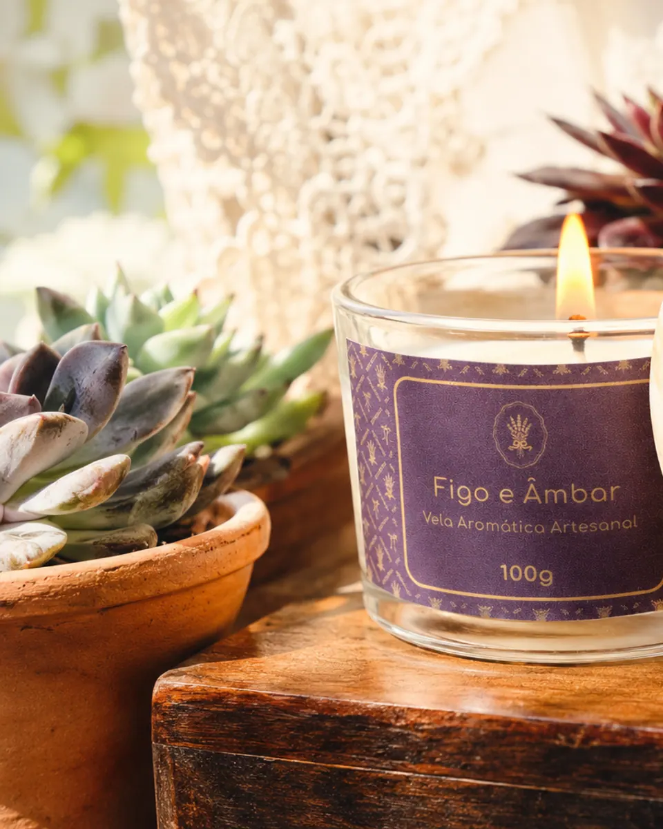 Vela Figo e Âmbar acesa junto à tampa de madeira e plantas
